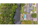 Aerial view of a home on a canal with a pool and lush greenery surrounding the backyard at 516 7Th Se St, Largo, FL 33771