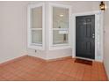 Cozy entrance to unit 202 with tile flooring, windows and a dark-colored front door at 5430 Eagles Point Cir # 202, Sarasota, FL 34231