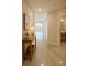 Bright hallway featuring tile flooring, neutral walls, and access to a half-bath with modern fixtures at 5430 Eagles Point Cir # 202, Sarasota, FL 34231