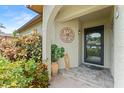 Inviting front porch with tile flooring, decorative plants, and an ornamental wall hanging at 6289 107Th N Ave, Pinellas Park, FL 33782