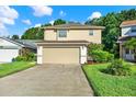 Inviting exterior of a two-story home featuring a two-car garage, lush lawn, and neatly landscaped front yard at 6439 Gentle Ben Cir, Wesley Chapel, FL 33544