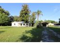An inviting property with a white brick house, screened porch and separate garage and car port at 8807 Mary Ivy Dr, Plant City, FL 33567
