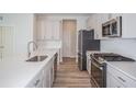 Contemporary kitchen featuring stainless steel appliances, gray cabinets, and quartz countertops on the island at 10036 Surrey Rose Dr, San Antonio, FL 33576