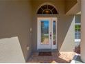 Close-up of the front door showcasing its glass design and sidelights, complemented by a neutral exterior paint color at 11153 Biddeford Pl, New Port Richey, FL 34654