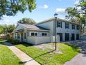Home featuring an attached garage and a well-manicured lawn with sidewalk at 11799 Raintree Dr, Temple Terrace, FL 33617