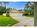 Inviting one-story home boasts a three-car garage, lush landscaping, and a well-manicured lawn at 12031 Mountbatten Dr, Tampa, FL 33626