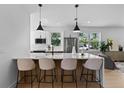 Contemporary kitchen island with seating, pendant lights and stainless appliances, connecting to living area at 1500 49Th N St, St Petersburg, FL 33710