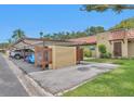 The property features covered parking adjacent to the front of the house with a charming terracotta tile roof at 1701 Pinehurst Rd # 33E, Dunedin, FL 34698