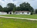 Attractive single-story home featuring a spacious lawn and a detached garage at 17048 State Road 54, Lutz, FL 33558