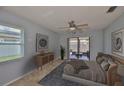 Comfortable bedroom with neutral tones, ceiling fan, and sliding glass doors to a private outdoor patio at 1717 Atrium Dr, Sun City Center, FL 33573