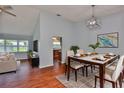 Inviting dining area with a modern light fixture, stylish table setting, and hardwood floors at 1717 Atrium Dr, Sun City Center, FL 33573