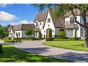 Charming front exterior of a two-story home featuring a fountain, lush lawn, and elegant architectural details at 18521 Wayne Rd, Odessa, FL 33556
