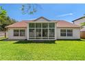 Expansive backyard with well-maintained lawn and large glass windows for sunroom at 19206 Ivy Oak Way, Tampa, FL 33647