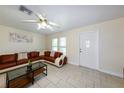 Inviting living room with tile flooring, a ceiling fan, and a stylish sectional sofa at 22442 Vale Ave, Punta Gorda, FL 33980