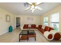 Comfortable living room features tile flooring, a fan, and a modern sectional sofa at 22442 Vale Ave, Punta Gorda, FL 33980