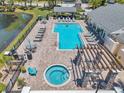 Aerial view of the community pool and hot tub with lounge chairs, tables, and a covered area at 3301 Haviland Ct # 301, Palm Harbor, FL 34684