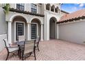 Cozy outdoor patio with brick flooring, seating, and classic architectural details at 3500 Ballastone Dr, Land O Lakes, FL 34638