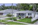 Charming single-story home with well-manicured lawn, picket fence, screened porch and detached garage at 411 Locklie St, Dunedin, FL 34698