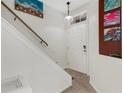 Welcoming entryway featuring a white front door, tile flooring, and wall art at 4322 Fincastle Ct, Tampa, FL 33624