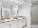 Bright bathroom featuring double sinks, granite countertops, and a glass-enclosed shower at 4401 S Trask St, Tampa, FL 33611