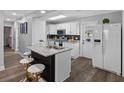Updated kitchen with white cabinets, granite countertops, stainless steel appliances, and breakfast bar at 4401 S Trask St, Tampa, FL 33611