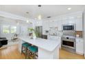 Open kitchen featuring white cabinets, quartz countertop island, and stainless steel appliances at 4711 12Th N St, St Petersburg, FL 33703