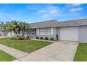 Charming townhome with a well-maintained lawn, mature palm trees, and an attached single car garage at 502 Cara Ct # 502, Largo, FL 33771