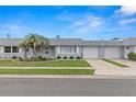 Charming townhome with a well-maintained lawn, mature palm trees, and an attached single car garage at 502 Cara Ct # 502, Largo, FL 33771