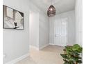 Welcoming entryway features neutral paint, tile flooring, and stylish light fixture at 6035 Nikki Ln, Odessa, FL 33556