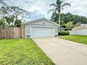 Charming single-story home featuring a well-manicured lawn and a two-car garage at 630 Timber Bay W Cir, Oldsmar, FL 34677