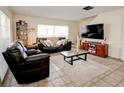 Cozy living room showcasing tile flooring, plush couches, and a modern entertainment center at 637 Kensington Lake Cir, Brandon, FL 33511