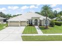 Charming home with a well-manicured lawn, mature landscaping, and welcoming front entrance at 6905 Arabian Rd, Odessa, FL 33556