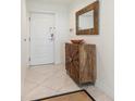 Condo foyer with decorative mirror and wood cabinet, providing a stylish welcome at 706 Bayway Blvd # 503, Clearwater, FL 33767