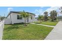 Angle shot of a home's front exterior, showcasing lush lawn, modern design, and the charming walkway to the entrance at 711 42Nd S Ave, St Petersburg, FL 33705