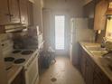 Dated kitchen with wooden cabinets, white appliances, and a view to the backyard at 729 41St St, Sarasota, FL 34234