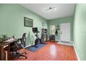 Bright exercise room featuring cherry wood floors, green walls, and exercise equipment at 9206 River Rock Ln, Riverview, FL 33578