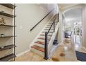 Modern staircase featuring wooden treads, white risers, and a sleek black handrail, plus open floorplan at 1031 Andrew Aviles Cir, Tampa, FL 33619