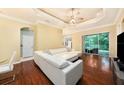 Open living room boasts hardwood floors, tray ceilings, a modern ceiling fan, and natural light at 11220 Paradise Pointe Way, New Port Richey, FL 34654