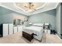 Cozy main bedroom with a ceiling fan, dresser, and a comfortable king-sized bed at 11220 Paradise Pointe Way, New Port Richey, FL 34654