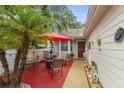 Cozy outdoor patio space with red brick pavers, sun umbrella, and outdoor furniture at 12529 Knollbrook Ln, Hudson, FL 34669