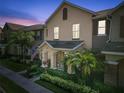 Charming two-story home with front yard featuring lush landscaping and an inviting porch during sunset at 14135 Stowbridge Ave, Tampa, FL 33626