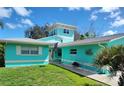 Beautiful turquoise single-Gathering home with a well-kept lawn and an inviting front entrance at 1626 Sea Breeze Dr, Tarpon Springs, FL 34689
