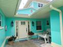 Inviting covered front porch with seating, decorative lanterns, and a welcoming entrance at 1626 Sea Breeze Dr, Tarpon Springs, FL 34689