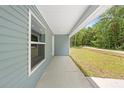 Side porch with a large window on the exterior of a light blue single story home at 19275 Wildwood Dr, Brooksville, FL 34601