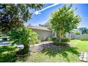 Landscaped side yard featuring lush greenery, decorative rock beds, and a well-manicured lawn at 19555 Timberbluff Dr, Land O Lakes, FL 34638