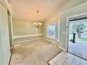 Dining room featuring a classic chandelier, light green walls, and a bright window for natural lighting at 2068 Diane Ave, Palm Harbor, FL 34683