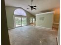 Spacious living room with high vaulted ceilings, a ceiling fan, and sliding glass doors to the backyard at 2068 Diane Ave, Palm Harbor, FL 34683