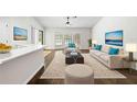 Bright living room featuring hardwood floors, natural light, and neutral furniture at 2141 Coachman Rd, Spring Hill, FL 34608