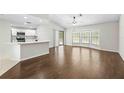 Open-concept living space with hardwood floors, a breakfast bar, and ample natural light at 2141 Coachman Rd, Spring Hill, FL 34608