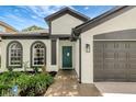 Beautiful home exterior showcasing a tile pathway, a two-car garage and three arched windows at 22824 Marsh Wren Dr, Land O Lakes, FL 34639